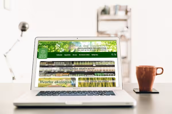 Bilde av sanabona.no vist på bærbar PC, med lenke til referanseside.